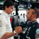 toto-wolff-lewis-hamilton shaking hands with another man in a racing suit